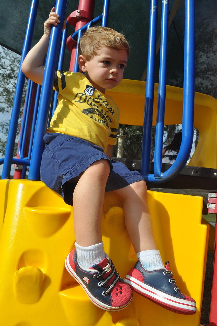 Kaden Pomeroy, 2, receives help down the playground stairs from his dad, Kevin, not pictured.