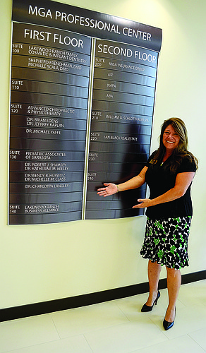 Annette Gueli, 2014 chairwoman of the Lakewood Ranch Business Alliance, shows off signage for the group's new office location in the MGA Professional Center.