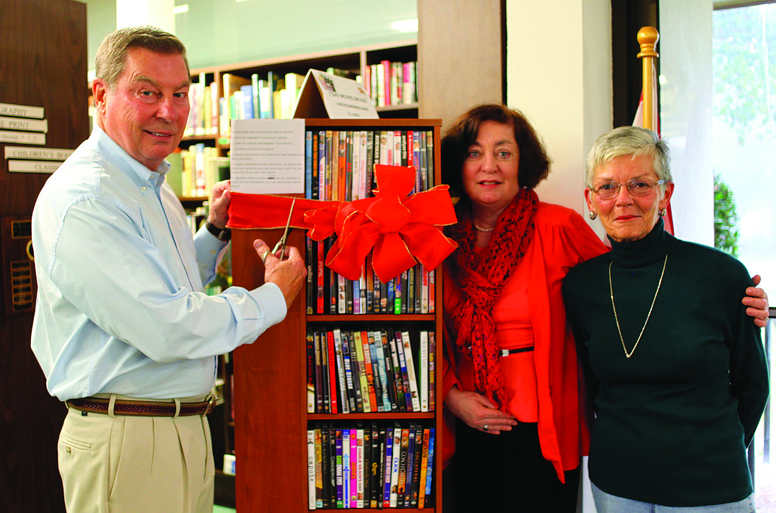 On Tuesday, Jan. 14, Ray Rajewski cuts the ribbon on his recently donated DVD collection at the Longboat Library with Patrice Greene and Joan Rotenberg.
