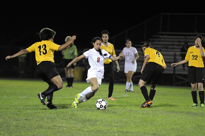 Cardinal Mooney senior defender Jasmine Rosales controls the ball around a host of Booker midfielders.