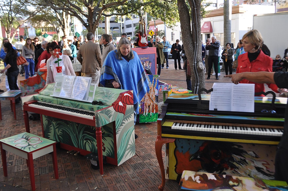 A crowd looks over six pianos, decorated by local artists, before a concert event Friday. The pianos, part of the Sarasota Keys project, will be located in various downtown locations through May.