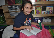 Fourth-grader Lizett Hernandez read under the light.