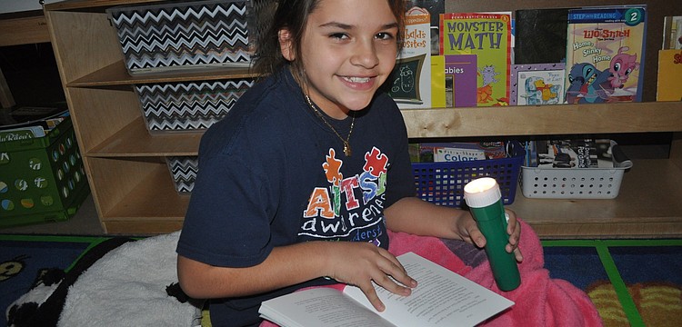 Fourth-grader Lizett Hernandez read under the light.