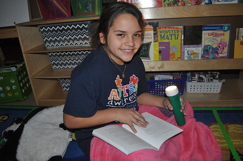 Fourth-grader Lizett Hernandez read under the light.