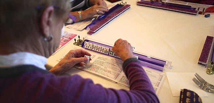 Barb Kiefer arranges her tiles during a game of mahjong.