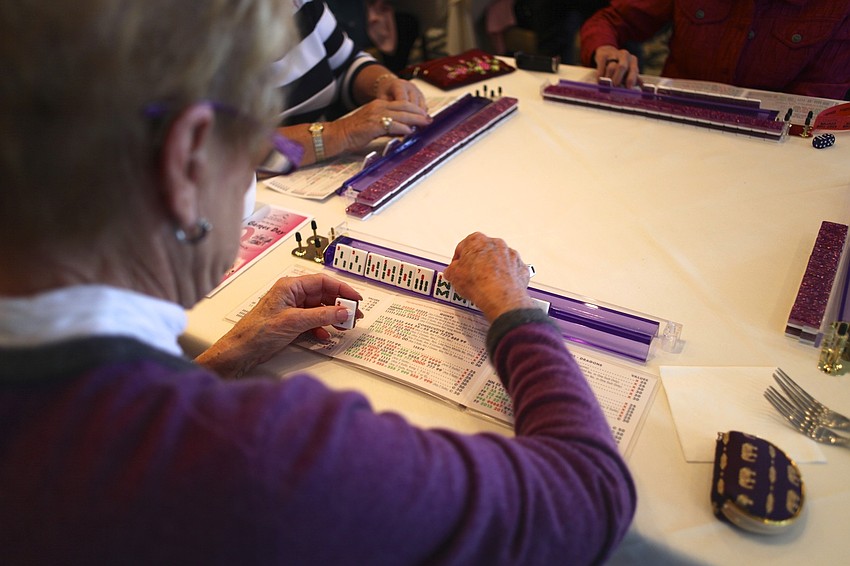 Barb Kiefer arranges her tiles during a game of mahjong.