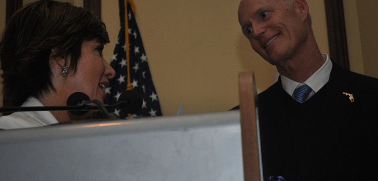 Mary Dougherty-Slapp, the executive director of the Builders Exchange, presented Gov. Rick Scott with a gift after he spoke.