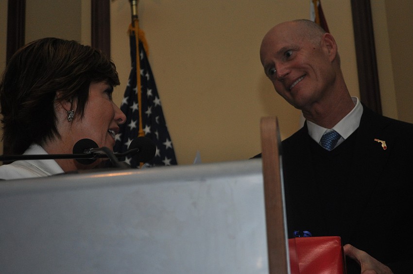 Mary Dougherty-Slapp, the executive director of the Builders Exchange, presented Gov. Rick Scott with a gift after he spoke.