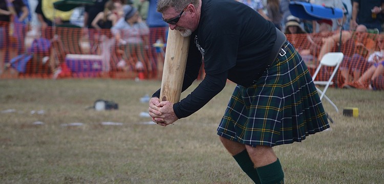 David Turnbull runs with the caber.