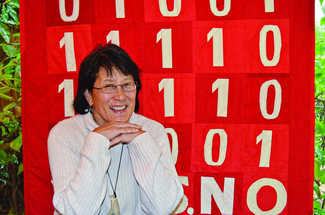 Janice Smyth with her quilt "BinaryCode," her second quilt in a series of three focused on codes.
