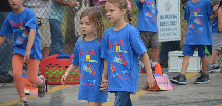 Aubrey Mocherman and Emilia Marr hold hands while walking.