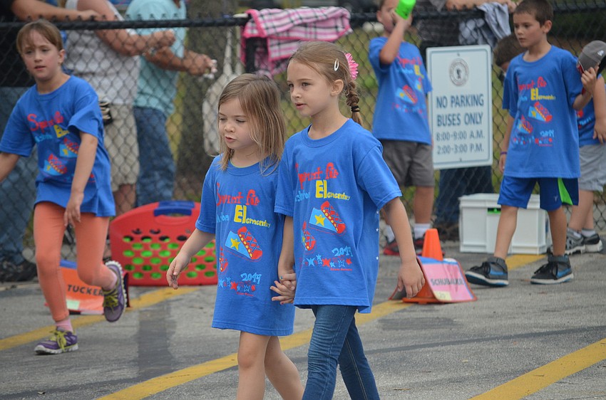 Aubrey Mocherman and Emilia Marr hold hands while walking.