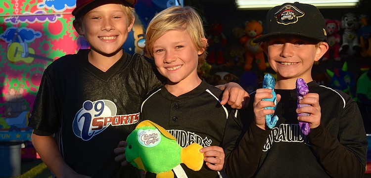Alden Wright, 11, Isaac Wright, 8, and Jack Muller, 8, enjoy the festival after their baseball game.