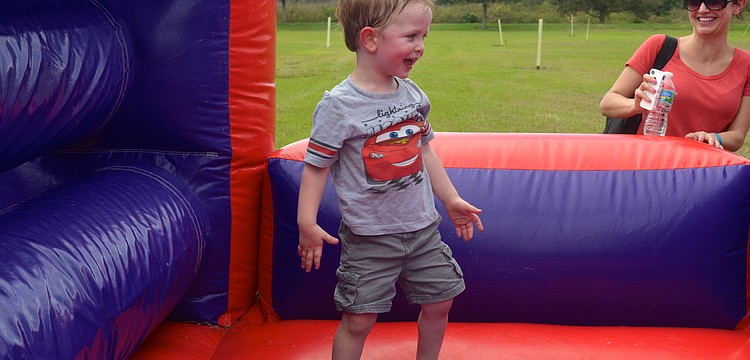 Two-year-old Kellan Jones plays around on an inflatable obstacle course.