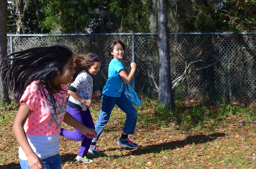 Ten-year-olds Mariana Cruz, Alex Vaca and Ayaka Quesen sprint around the field.