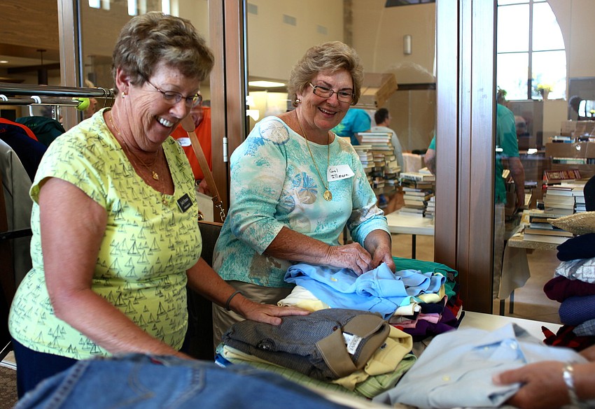 Judy Strauss and Carol Fillmore fold and sort shirts.