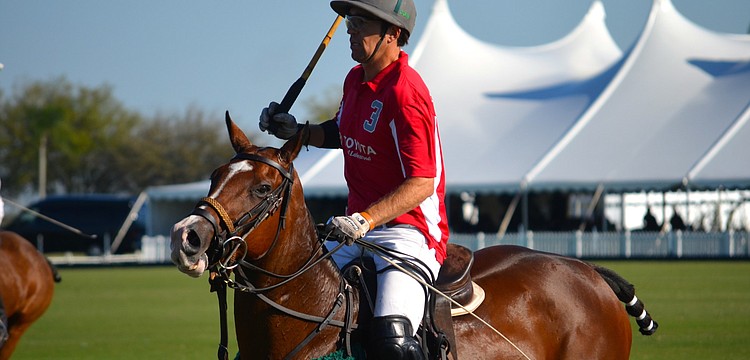 Chris Nevins chases after the ball during the polo match.