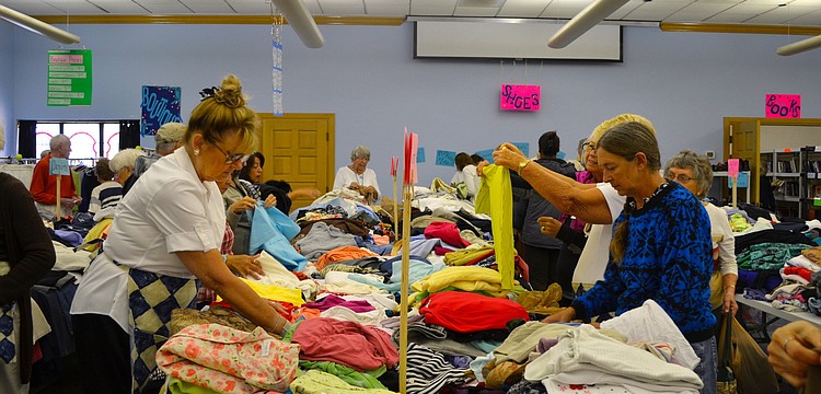 The womenâ€™s clothing section is a busy area during the sale.