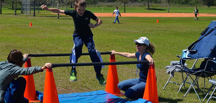 Ten-year-old Austin Parcels jumps during the schoolâ€™s obstacle course.