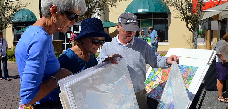 Roxanne Leezer, and Tina and Bill Moore peruse artwork.
