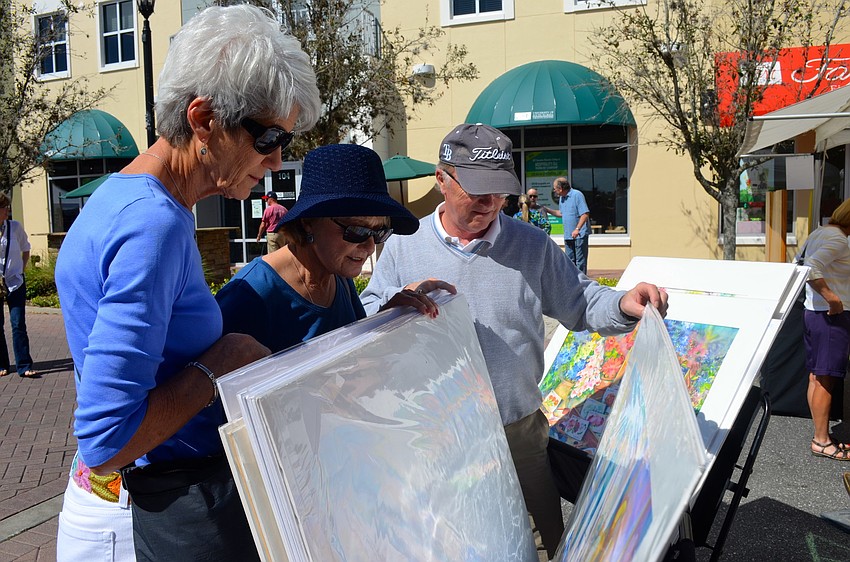Roxanne Leezer, and Tina and Bill Moore peruse artwork.