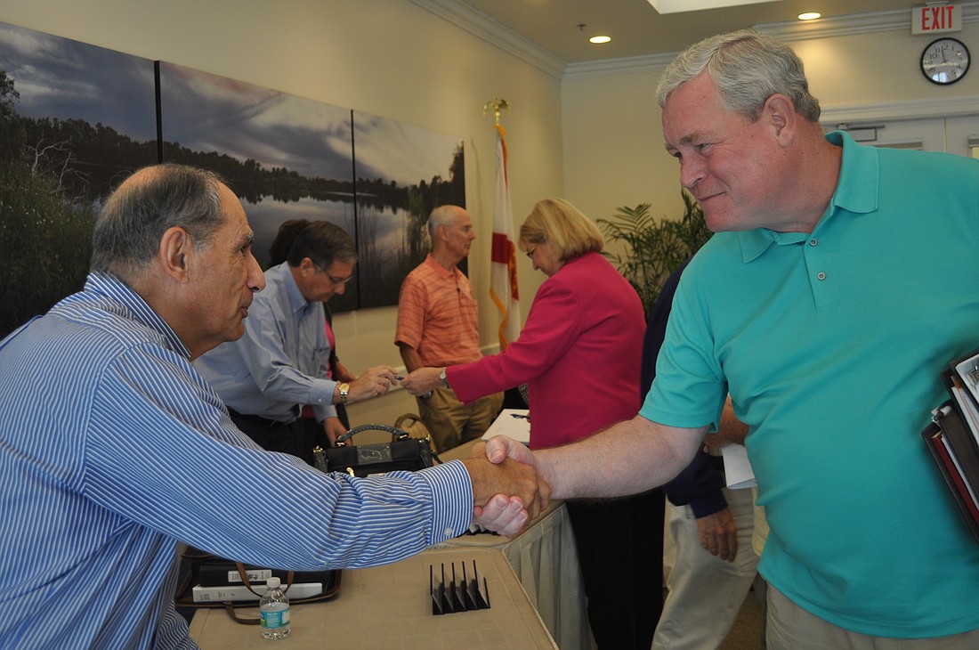Robert Burstein, Lakewood Ranch CDD 6 supervisor, and David Emison, CDD 5 supervisor, congratulate each other after passing the cost-sharing agreement.