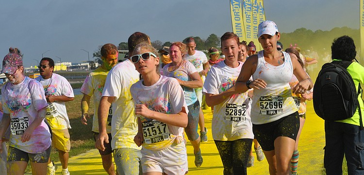 Runners run through yellow dye.