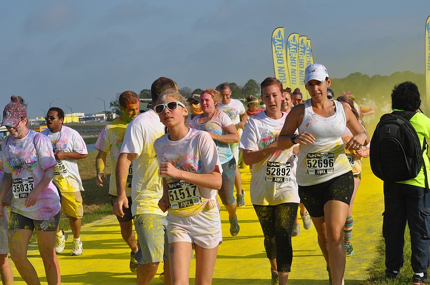 Runners run through yellow dye.