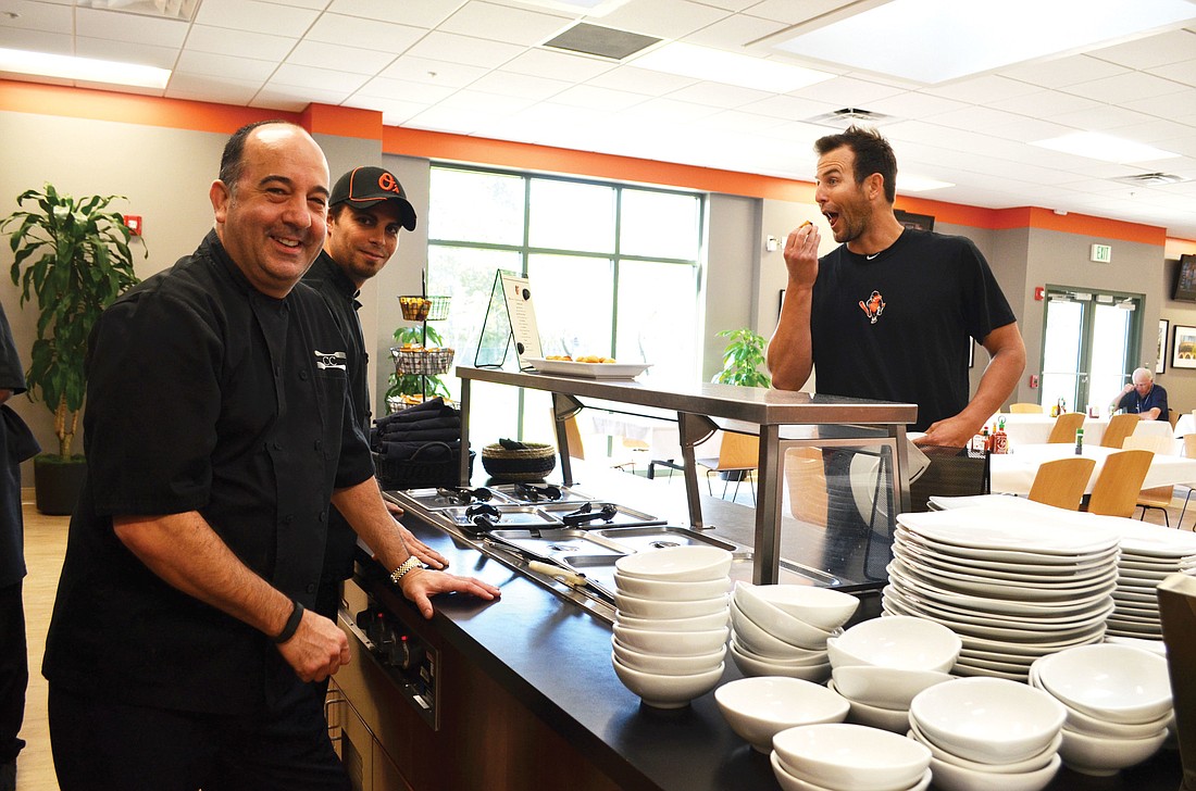 Chef Chris Covelli and Chef Gary Mazan try not to laugh as pitcher Darren O'Day practices his well-known tomfoolery.