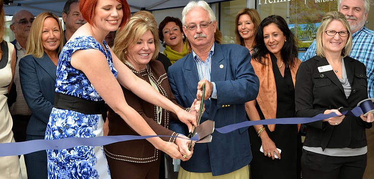 Ann Shako, Judy Green and Mayor Jim Brown cut the ribbon in front of Premier Sothebyâ€™s International Realty in the Publix Plaza.