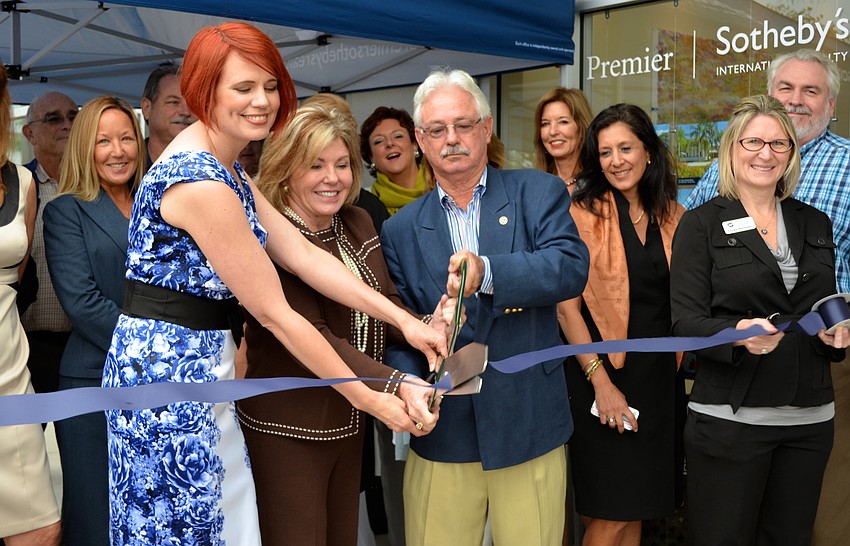 Ann Shako, Judy Green and Mayor Jim Brown cut the ribbon in front of Premier Sothebyâ€™s International Realty in the Publix Plaza.