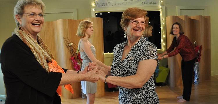 Friends Janet Davis and Lois Kummery learn a latin dance as part of the dayâ€™s festivities