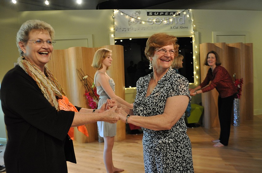 Friends Janet Davis and Lois Kummery learn a latin dance as part of the dayâ€™s festivities