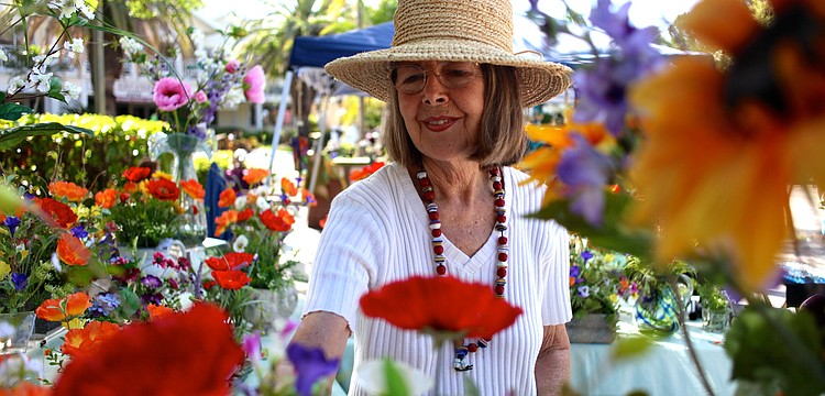 Bonita Mertes arranges her â€œperpetualâ€ flower creations at her Bloominâ€™ Elegant booth.