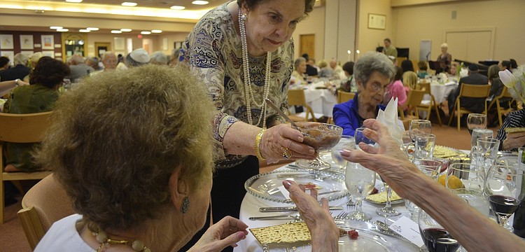 Ruth Engman passes the bitter herbs to Maye Lavinson.