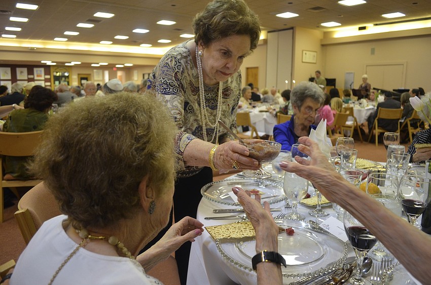 Ruth Engman passes the bitter herbs to Maye Lavinson.