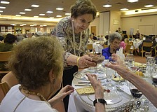 Ruth Engman passes the bitter herbs to Maye Lavinson.