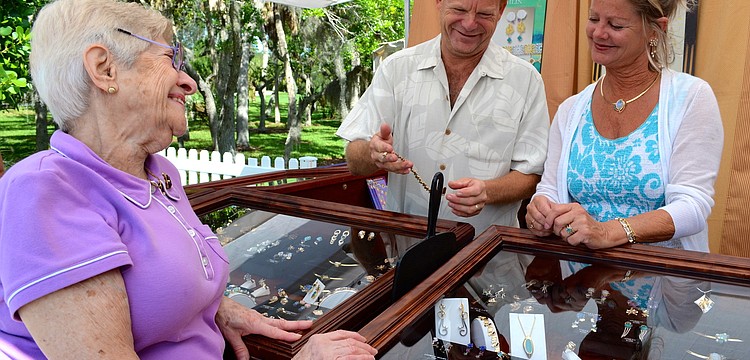 Beatrice Einstein laughs with Skip Ennis and Ann Richards at Joan Michlin's jewelry booth.