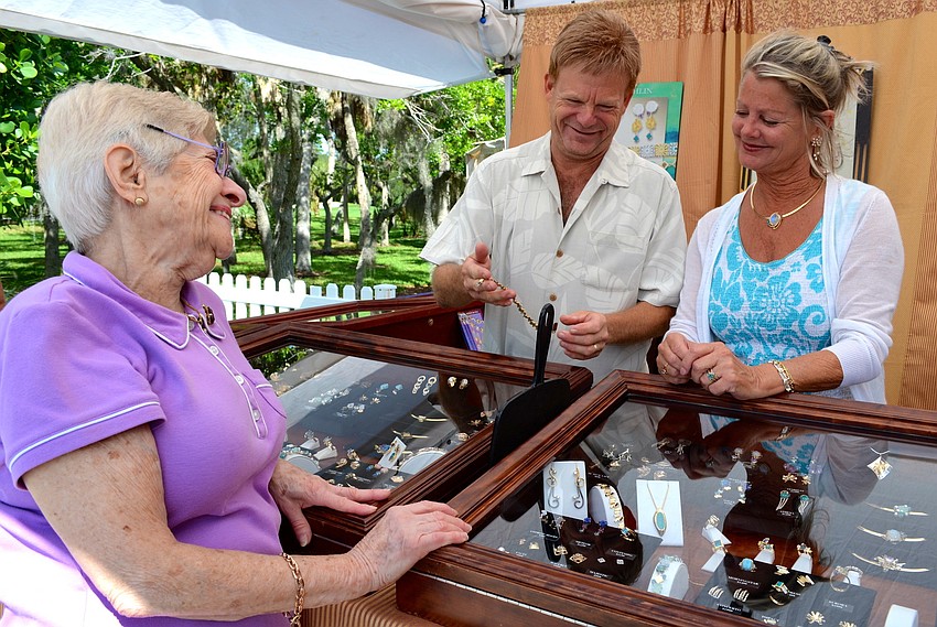Beatrice Einstein laughs with Skip Ennis and Ann Richards at Joan Michlin's jewelry booth.