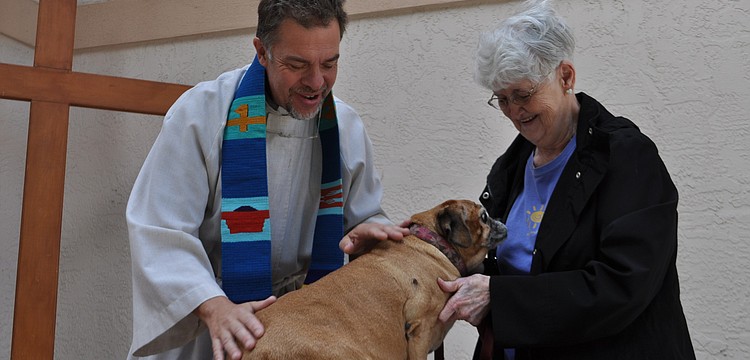 The Rev. Brian Bagley-Bonner blesses Piper, a beagle/pug mix owned by Marge Hooie.