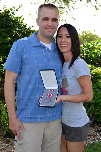 Ben and Melissa Grodi with the Meritorious Service Medal. Photo by Kelsey Grau