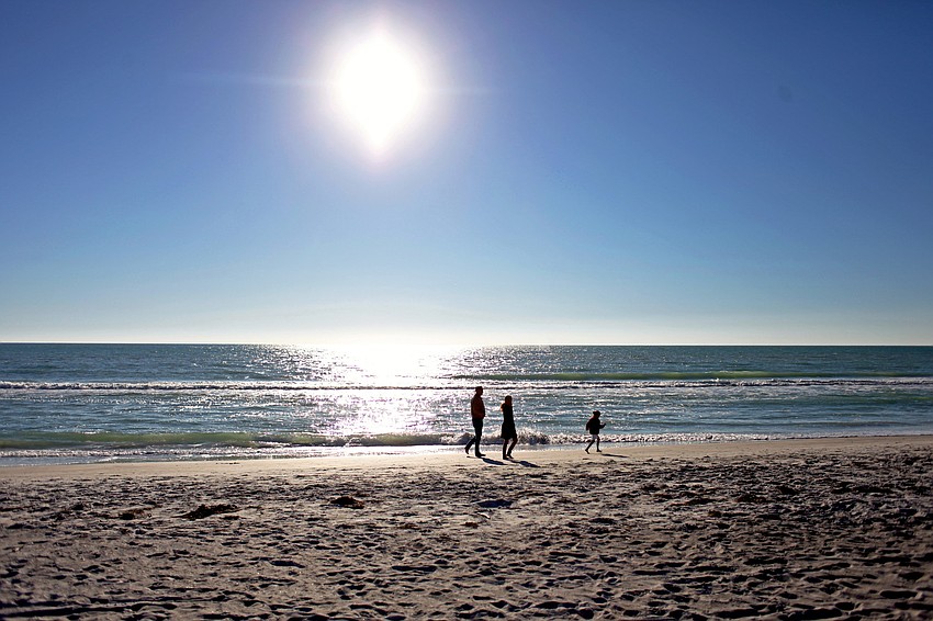 A family visiting from Massachusetts enjoys the sunshine on an afternoon walk along a Longboat Key beach on Tuesday, April 29.