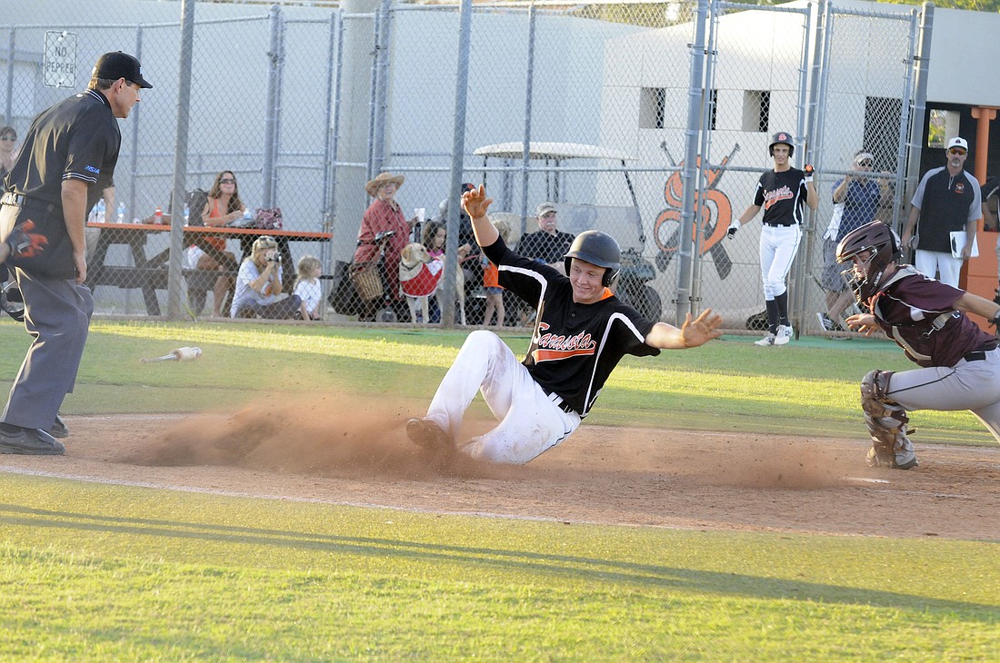 Sarasota High outfielder Matt Schlabach slides safely into home plate in the bottom of the first inning. Photos by Jen Blanco