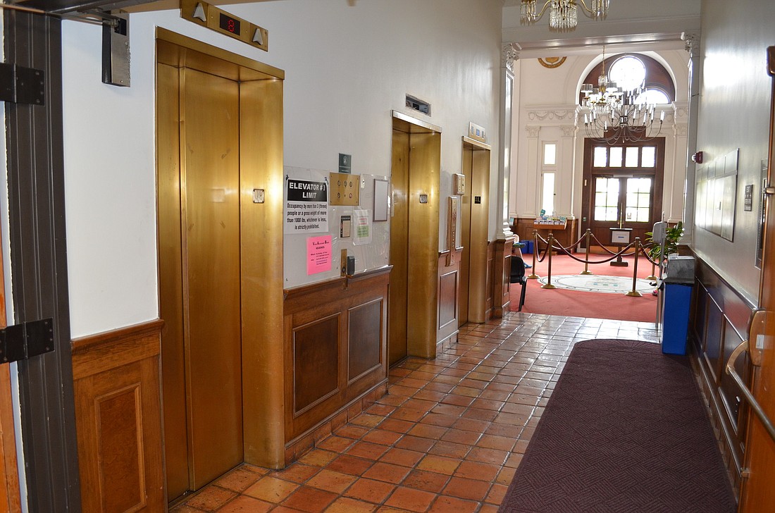 With repairs underway within the Terrace Administration Building, signs next to the troubled elevators inform visitors of weight restrictions and construction. Photo by David Conway