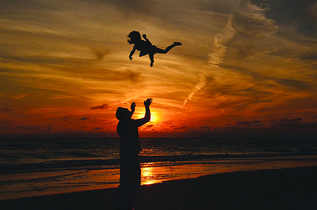 Richard Crooks throws his daughter, Ayla, up in the air during sunset on Longboat Key.