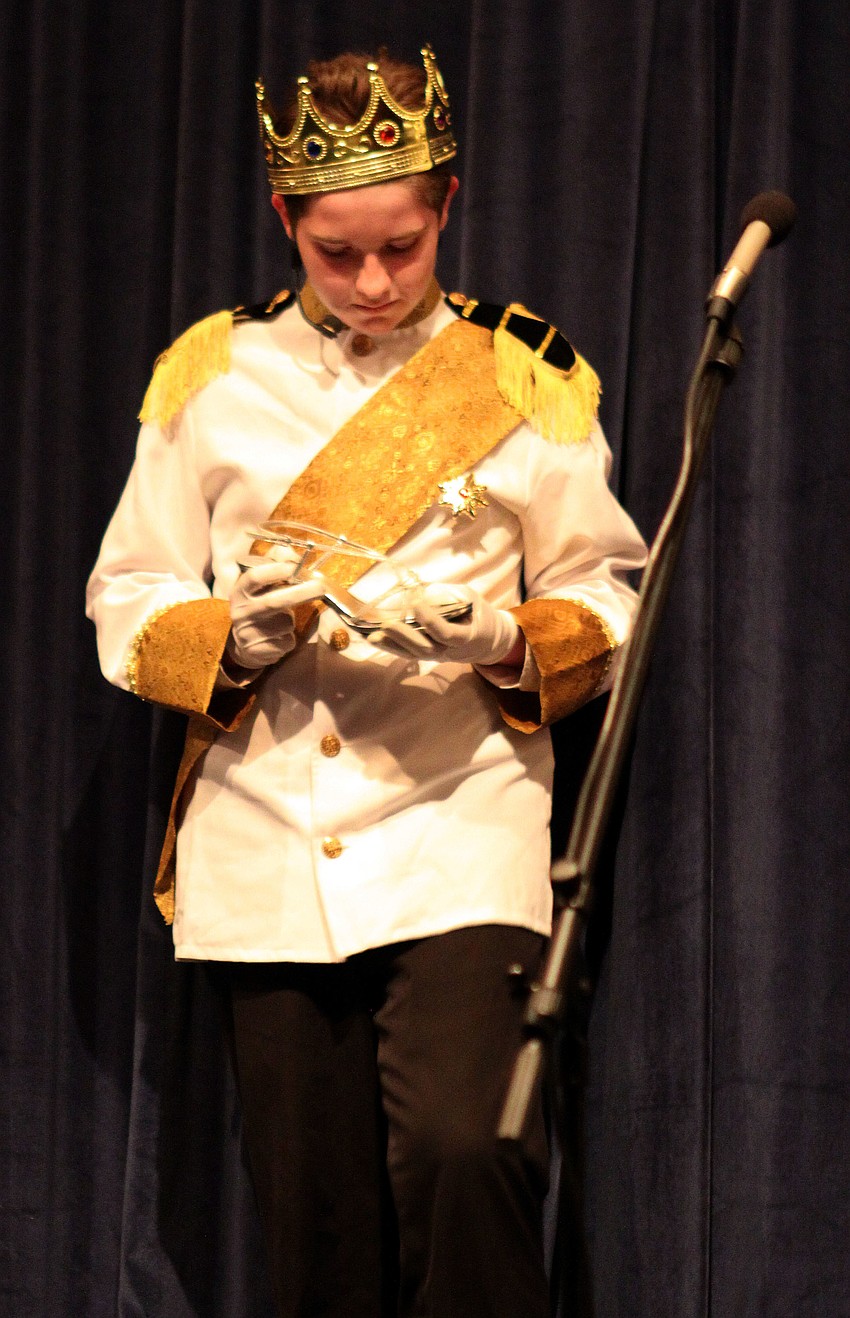 Prince, Kyler Inman, holds Cinderellaâ€™s slipper.