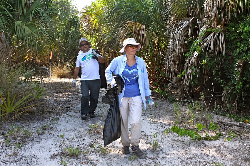 Joseph Wrona and Barbara Mikulski make their way back to the water after picking up trash.