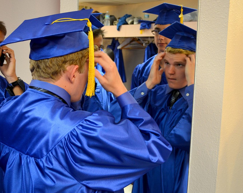 Austin Sandefur adjusts his hat in the mirror before the ceremony.