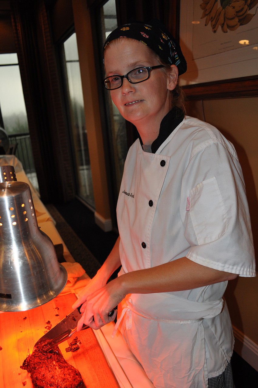 Jeanette Scott serves porkloin to guests.