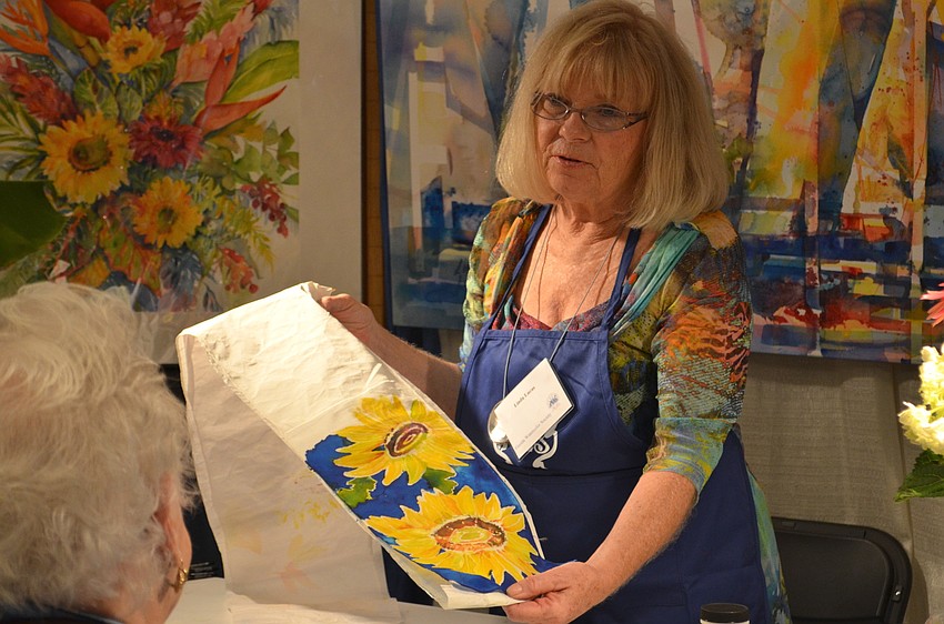 Lakewood Ranch resident Linda Lucas shows an audience how she paints with ink